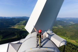 A man standing on a wind turbine
