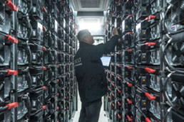Man standing between racks of electricity storage containers