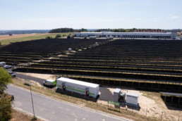 Solarpark von hinten mit Tesvoltspeicher im Vordergrund