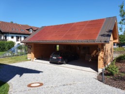 ein Carport mit roten Solarmodulen