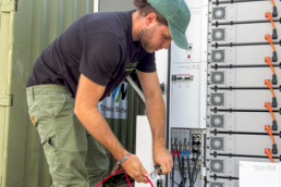 Ein Mann schließt Batteriespeicher von Tesvolt an.